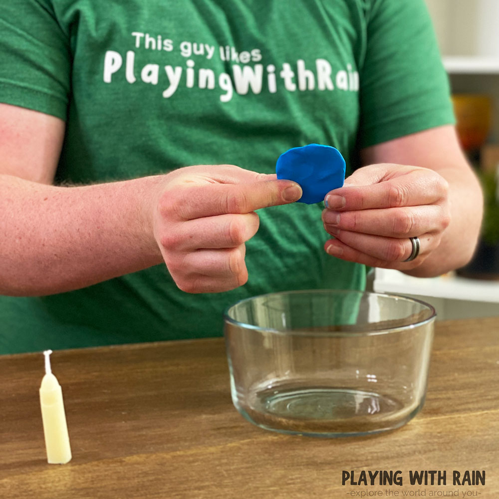 Use modeling clay to attach the candle to the bowl