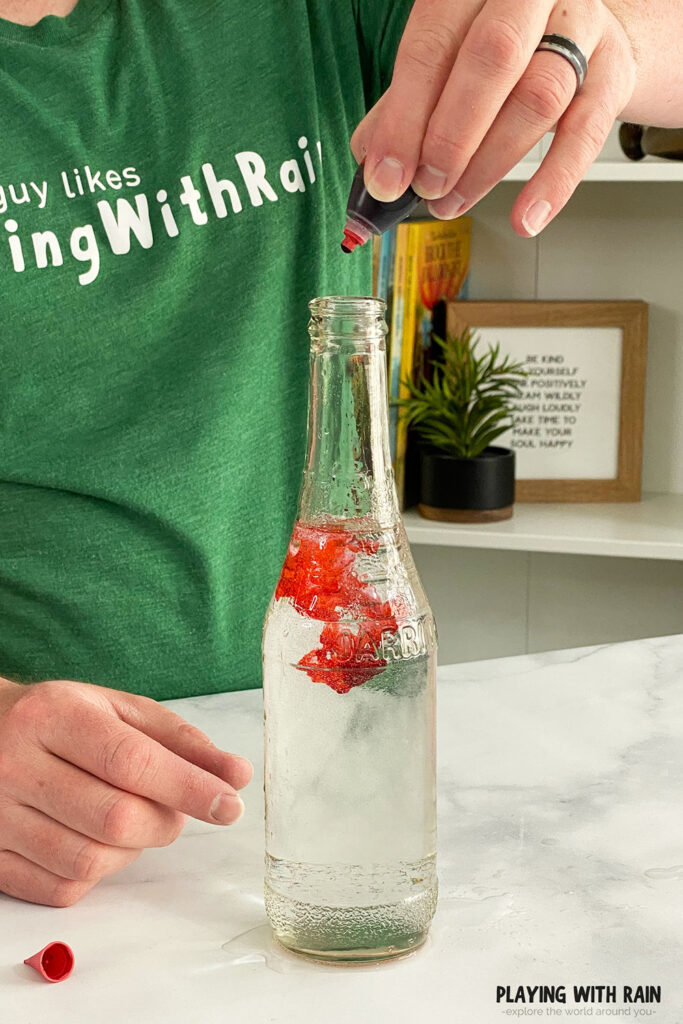Putting some red food coloring into a bottle