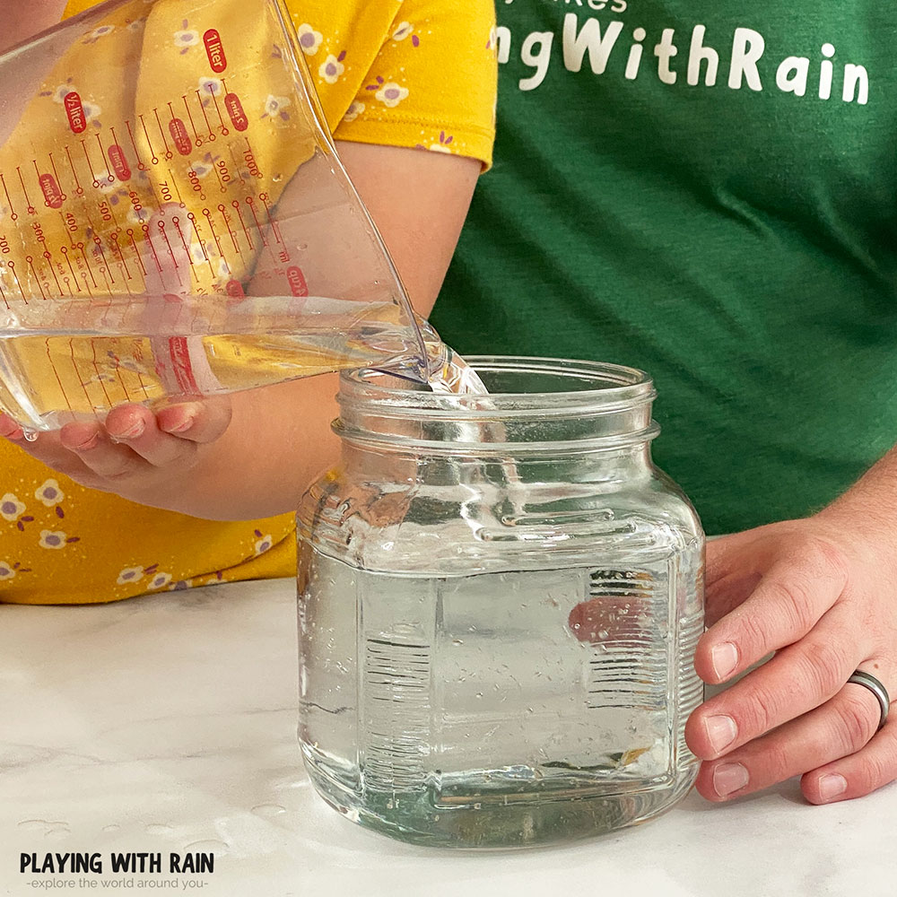Pouring water into a clear jar